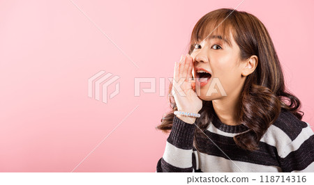 Asian happy portrait beautiful cute young woman teen standing hand on mouth talking news announcement studio shot isolated on pink background, Thai female shout out announcement Asian happy portrait beautiful cute young woman teen standing hand on mouth talking news announcement studio shot isolated on pink background, Thai female shout out announcement 118714316