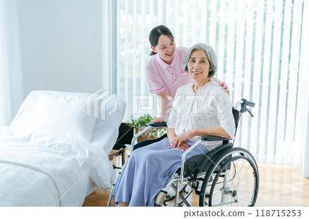 Senior woman living in a nursing home and a young caregiver Senior woman living in a nursing home and a young caregiver 118715253
