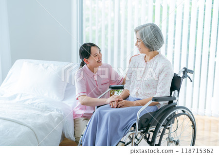 Senior woman living in a nursing home and a young caregiver 118715362