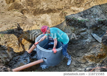 Connecting sewer pipe to septic tank made of concrete rings designed for wastewater treatment. 118715565