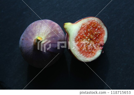 Purple figs on a black stone plate. Photo, background with fresh, juicy, ripe tropical fruits. Suitable for depicting vegetarian and raw, healthy food, harvest. Symbol of abundance and enlightenment. Purple figs on a black stone plate. Photo, background with fresh, juicy, ripe tropical fruits. Suitable for depicting vegetarian and raw, healthy food, harvest. Symbol of abundance and enlightenment. 118715653
