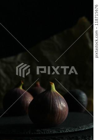 Purple figs on a black stone plate. Photo, background with fresh, juicy, ripe tropical fruits. Suitable for depicting vegetarian and raw, healthy food, harvest. Symbol of abundance and enlightenment. 118715676