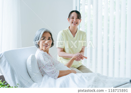 住在療養院的一名老年婦女和一名年輕護理人員 118715891