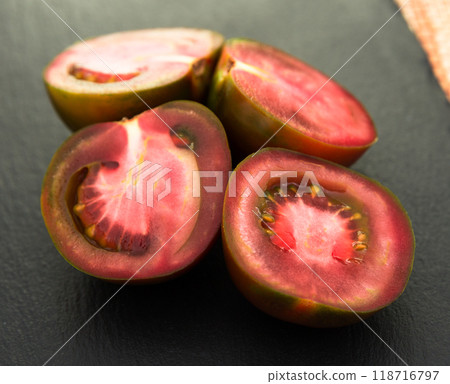 Black halves of tomatoes on black stone board Black halves of tomatoes on black stone board 118716797