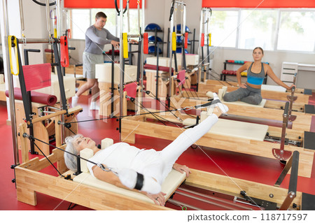 Elderly woman training her legs using straps 118717597