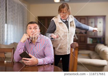 Woman scolding her adult son 118717661