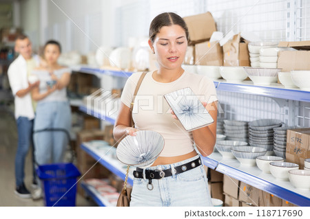 Young woman choosing plates in store Young woman choosing plates in store 118717690