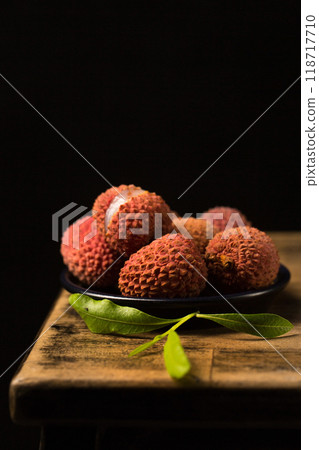 Small tropical lychee berries on a black plate in a minimalist style, low key Small tropical lychee berries on a black plate in a minimalist style, low key 118717710