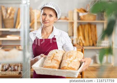 Positive female seller showing assortment of bakery 118717759