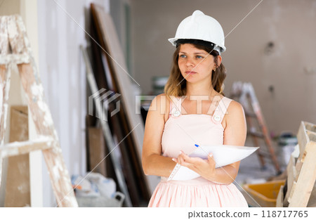 Woman construction manager checking project documentation 118717765