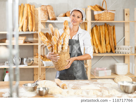 Female baker worker shows many products baguettes Female baker worker shows many products baguettes 118717766