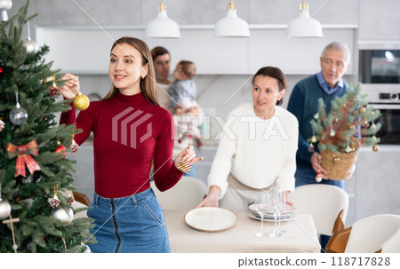 Woman decorating Christmas tree Woman decorating Christmas tree 118717828