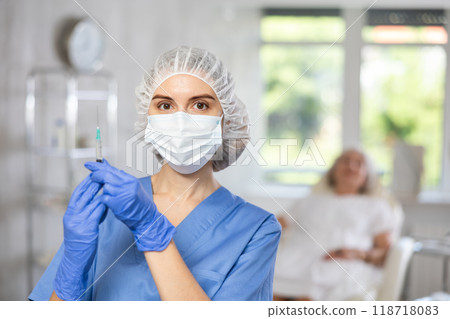 Young doctor with mask and syringe 118718083