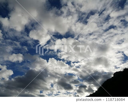 Dramatic Cloudscape With Blue Sky and Silhouetted Mountains 118718084