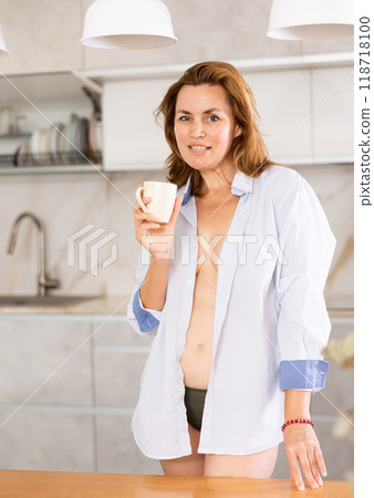 Adult woman in shirt posing in kitchen Adult woman in shirt posing in kitchen 118718100