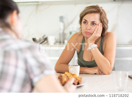 Two women friends share problems with each other in home kitchen 118718202
