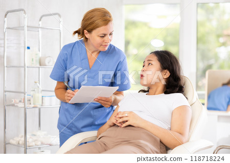 Middle-aged doctor consulting with documents 118718224