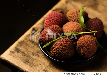 Tropical lychee berries on a black plate on a wooden background 118718375