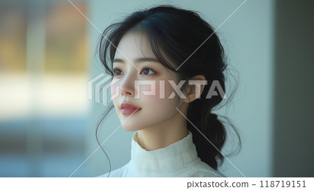A young Korean woman gazing thoughtfully, showcasing her features in soft morning light indoors A young Korean woman gazing thoughtfully, showcasing her features in soft morning light indoors 118719151