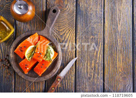 Fresh salmon fillets on dark wooden background with spices Fresh salmon fillets on dark wooden background with spices 118719605