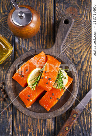 Fresh salmon fillets on dark wooden background with spices 118719606