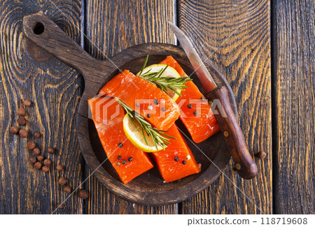 Fresh salmon fillets on dark wooden background with spices Fresh salmon fillets on dark wooden background with spices 118719608