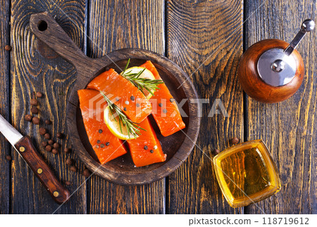 Fresh salmon fillets on dark wooden background with spices 118719612