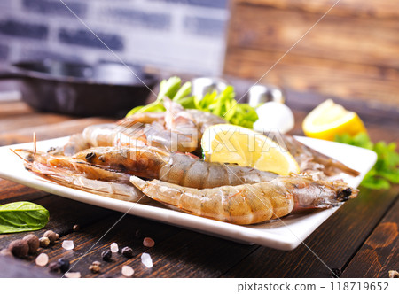 Uncooked Raw peeled tiger white shrimp prawn. Dark background. Uncooked Raw peeled tiger white shrimp prawn. Dark background. 118719652