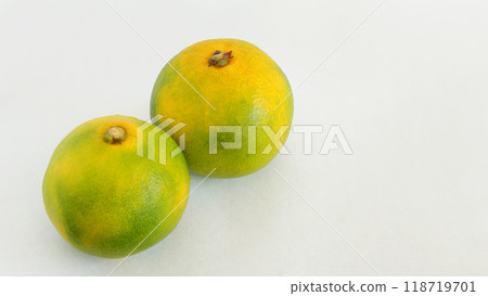 Autumn and winter fruits: 2 very early green mandarins: white background Autumn and winter fruits: 2 very early green mandarins: white background 118719701