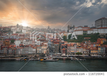 A breathtaking view of Porto, Portugal at sunset, featuring the Douro River, Ribeira district, Porto Cathedral, and Clerigos Tower under a partly cloudy sky. 118720041