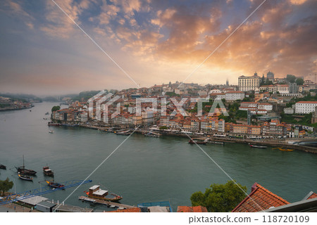 Breathtaking view of Porto, Portugal, featuring the Douro River, traditional boats, Ribeira district, Dom Luis I Bridge, and Porto Cathedral at sunset. Breathtaking view of Porto, Portugal, featuring the Douro River, traditional boats, Ribeira district, Dom Luis I Bridge, and Porto Cathedral at sunset. 118720109