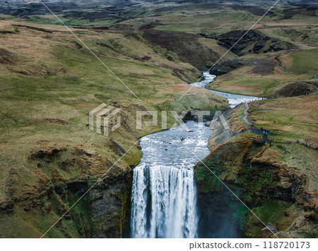 Impressively beautiful nature of Iceland during sunset. Skogafoss waterfall is one famous natural landmark and travel destination place of Iceland. Tourists ride horses near famouse waterfall. Impressively beautiful nature of Iceland during sunset. Skogafoss waterfall is one famous natural landmark and travel destination place of Iceland. Tourists ride horses near famouse waterfall. 118720173