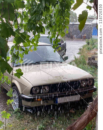 BMW E-30 in pouring rain. Legendary car BMW E-30.Old BMW 3 series with angel eyes optics. 118720330