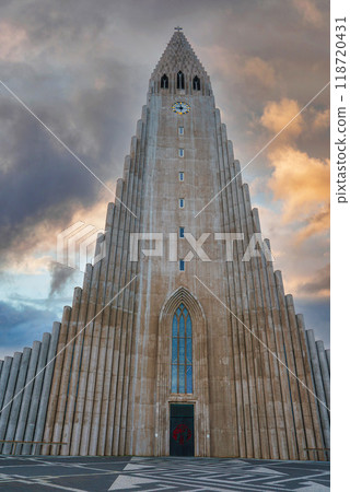 The Hallgrimskirkja church in Reykjavik, Iceland, features a tall, stepped concrete facade inspired by basalt lava flows, with dramatic clouds in the background. The Hallgrimskirkja church in Reykjavik, Iceland, features a tall, stepped concrete facade inspired by basalt lava flows, with dramatic clouds in the background. 118720431