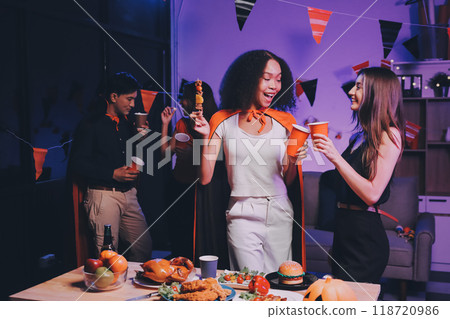 Joyful office Halloween party with coworkers in costumes, celebrating with drinks and laughter, fostering teamwork and festive spirit 118720986
