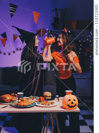 Joyful office Halloween party with coworkers in costumes, celebrating with drinks and laughter, fostering teamwork and festive spirit Joyful office Halloween party with coworkers in costumes, celebrating with drinks and laughter, fostering teamwork and festive spirit 118721005