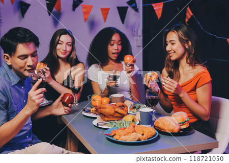 Joyful office Halloween party with coworkers in costumes, celebrating with drinks and laughter, fostering teamwork and festive spirit 118721050