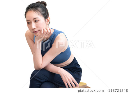 一個穿著運動服的女人坐著思考 一個穿著運動服的女人坐著思考 118721248