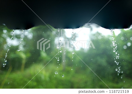 Rainwater dripping from the roof of the house and green trees 118721519