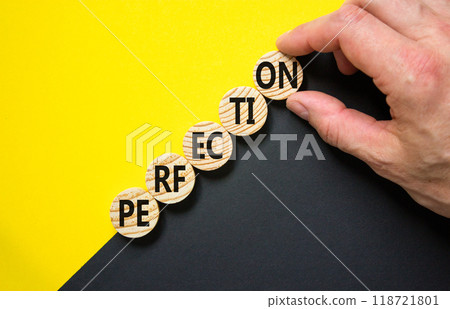 Perfection symbol. Concept word Perfection on beautiful wooden circles. Beautiful yellow and black background. Businessman hand. Business perfection concept. Copy space. Perfection symbol. Concept word Perfection on beautiful wooden circles. Beautiful yellow and black background. Businessman hand. Business perfection concept. Copy space. 118721801