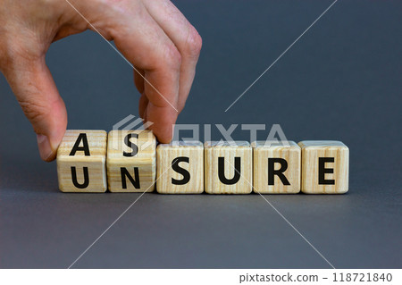 Assure or unsure symbol. Businessman turns wooden cubes and changes the concept word unsure to assure. Beautiful grey table, grey background, copy space. Business and assure or unsure concept. Assure or unsure symbol. Businessman turns wooden cubes and changes the concept word unsure to assure. Beautiful grey table, grey background, copy space. Business and assure or unsure concept. 118721840