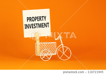 Property investment symbol. Concept words Property investment on beautiful white paper on wooden clothespin. Beautiful orange background. Bike model. Business Property investment concept. Copy space. 118721945