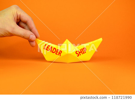 Leadership symbol. Concept word Leadership on beautiful yellow paper boat. Beautiful orange background. Businessman hand. Business leadership concept. Copy space. 118721990