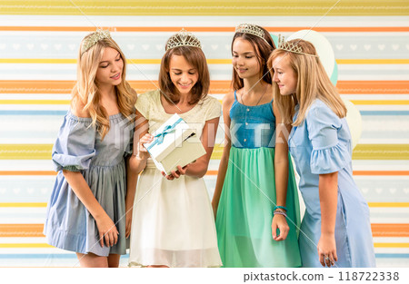 Girl receining a gift on a birthday party with friends 118722338