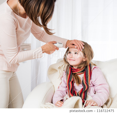 Mum measuring ill smiling daughter's temperature Mum measuring ill smiling daughter's temperature 118722475