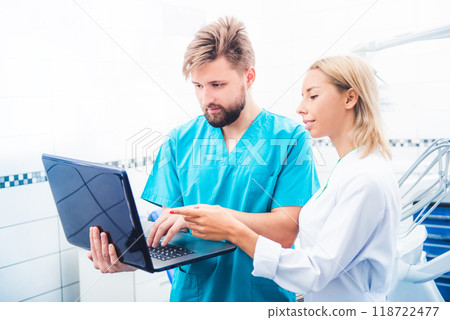 Dentists in uniform working with laptop 118722477