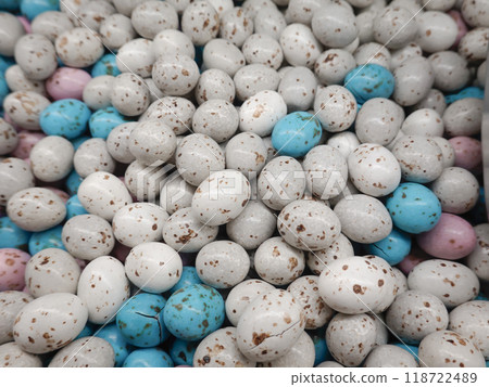 Lots of small white and blue candy coated chocolate eggs. 118722489