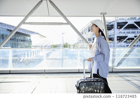 日本女旅客提著隨身行李箱走過機場 118723485