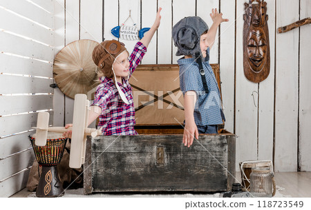 two little children-pilots fly with hands sitting in big old chest 118723549