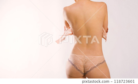 White slim woman with her bra unbuckled, wearing nice peachy underpants, backshot 118723601